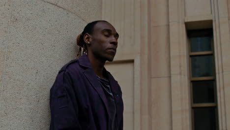 carefree black afro american male singer chills out outdoor alone , close up of man with modern clothing standing