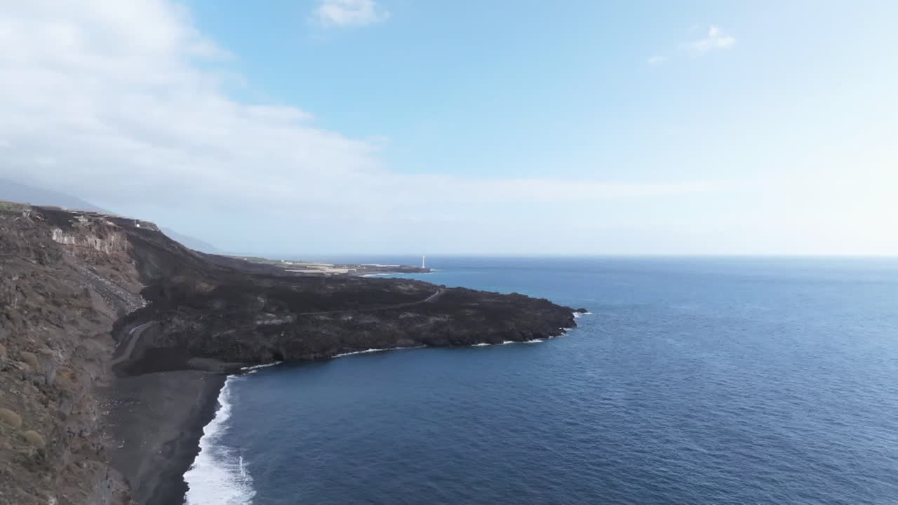 Volcanic Coastline with Lighthouse and Dark Sand Beach