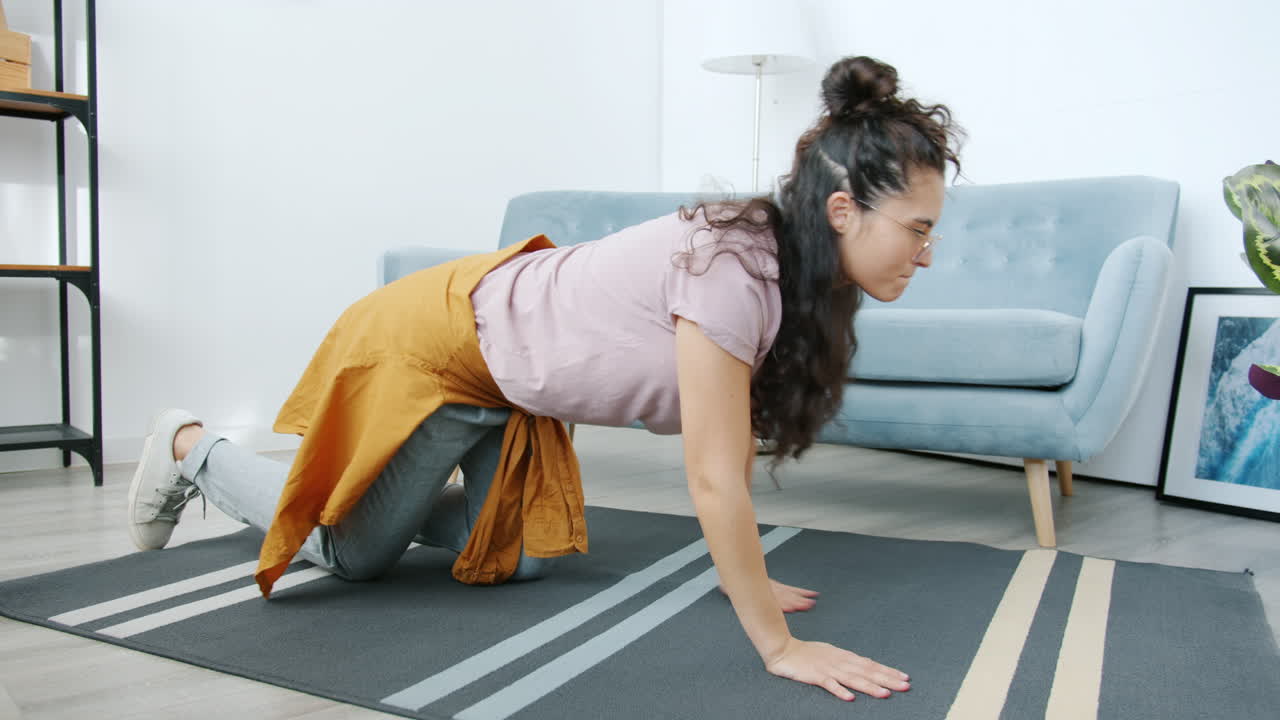 mujer enrollando una alfombra en una sala de estar
