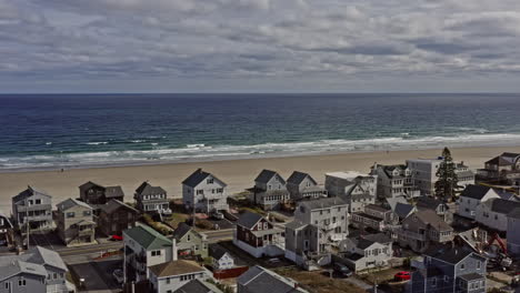 Wells-Maine-Aerial-v4-panoramic-view-capturing-beautiful-seascape-and-landscape-of-salt-marsh-river-estuary-with-rows-of-beachfront-residential-houses-and-cottages-during-autumn-season---October-2020