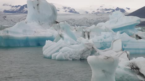 glacier lagoon in iceland with close up pan left to right of ice chunks