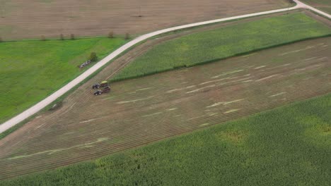 Vogelperspektive-Von-Landwirtschaftlichen-Traktoren-Auf-Dem-Feld,-Das-Maisstängel-Für-Viehfutter-Zerkleinert