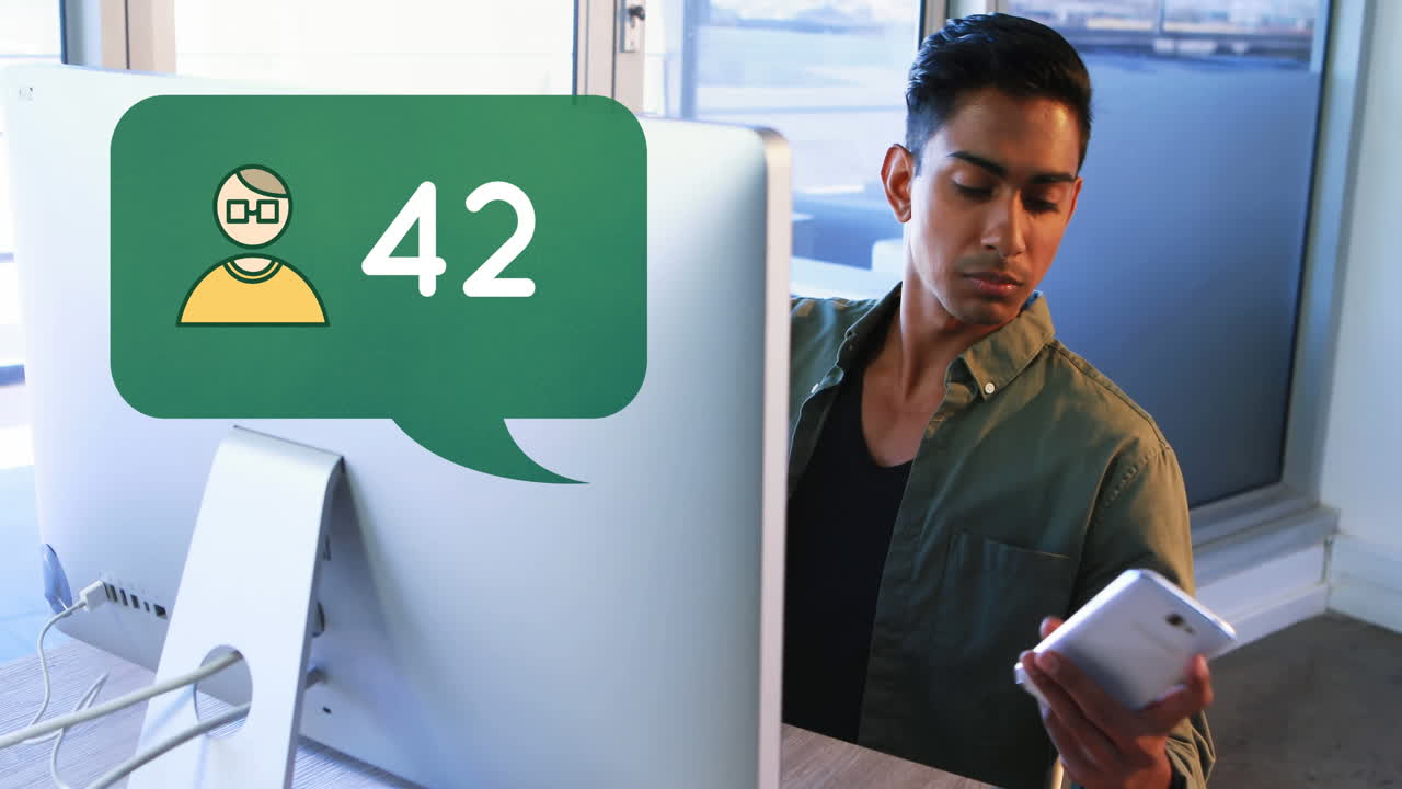 hombre comprobando su teléfono mientras trabaja en su computadora 4k