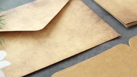 rustic kraft paper envelopes with daisy flower and green plant sprig