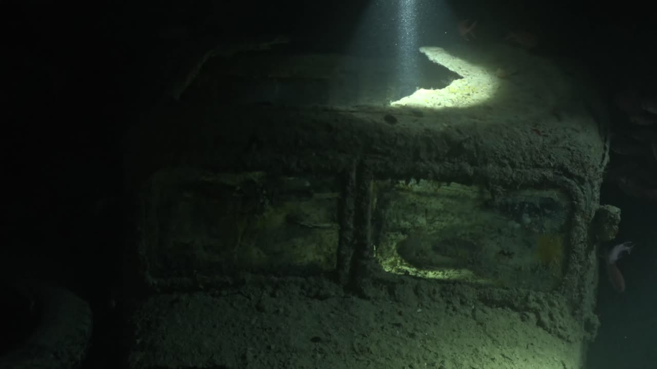 Mesmerizing underwater video of an old, corroded WWII-era car encrusted in marine growth and sediment on the SS Thistlegorm wreck in Egypt's Red Sea