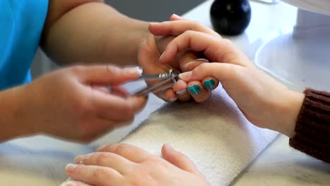 a girl has her nails cut in a beauty salon