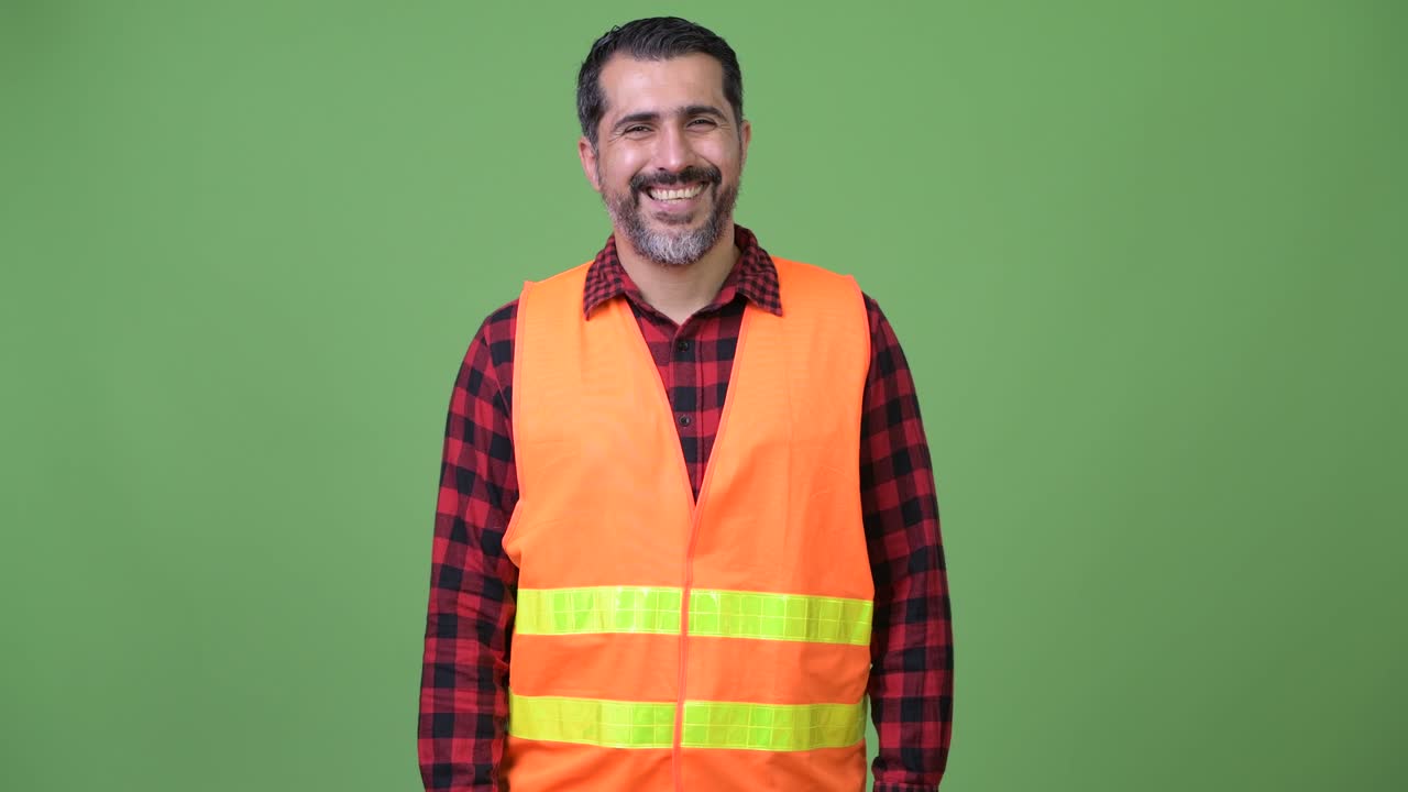 Handsome Persian bearded man construction worker with arms crossed