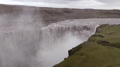 wide angle view of massive, foamy detifoss waterfall in iceland