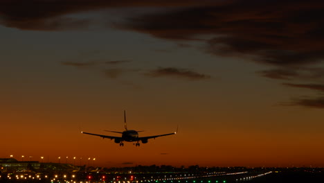 toma de seguimiento del aterrizaje del avión en el aeropuerto durante el crepúsculo cinematográfico