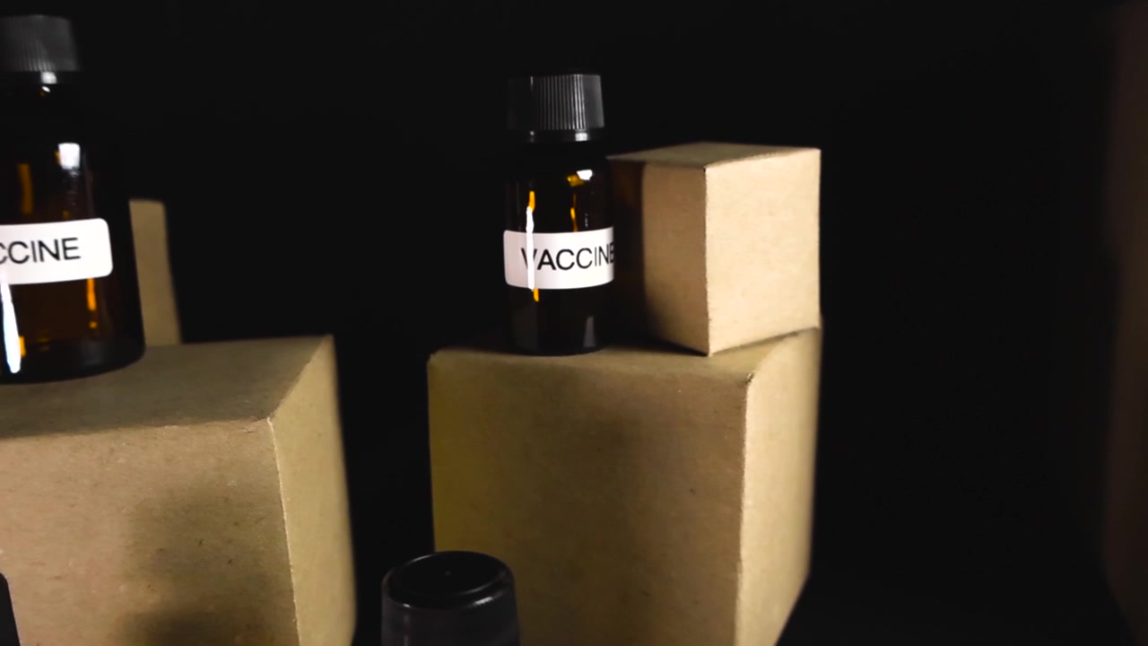 Forniture mediche in fiale di vetro ambrato e scatole di cartone in attesa di distribuzione. La scena concettuale evidenzia il processo di logistica e consegna di prodotti farmaceutici essenziali