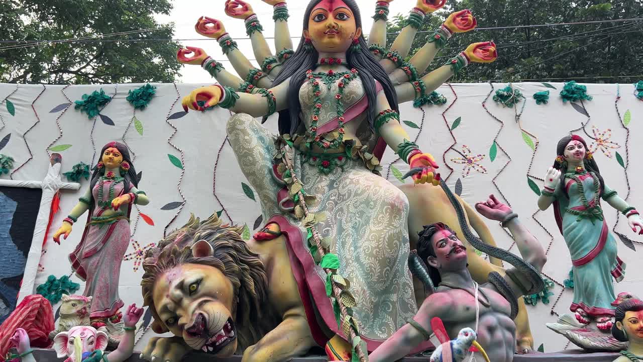 Round faced Durga idol with snake in her hand attacking Asur. Durga puja carnival procession.