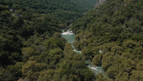 Drone-footage-revealing-a-wonderful-river-flowing-between-mountains-in-the-middle-of-the-jungle