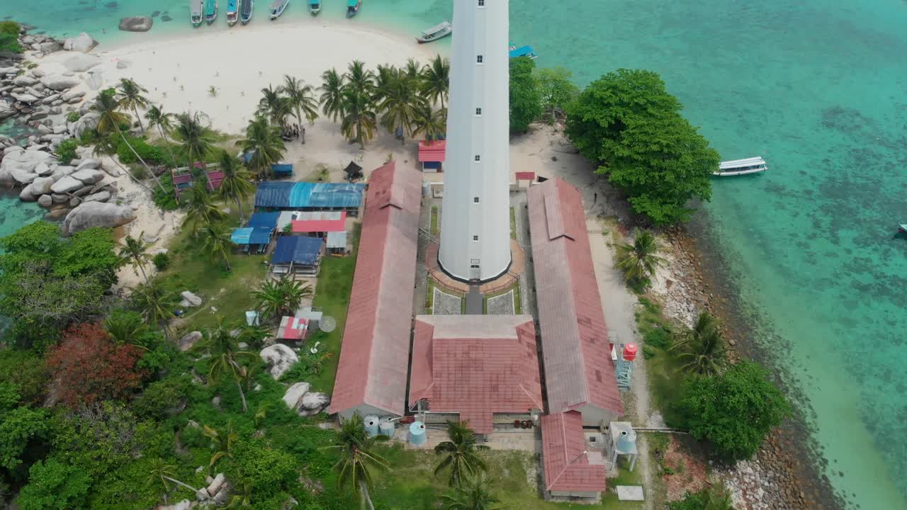 Belitung Endonezya'daki deniz ve plajla çevrili Pulau Langkuas adasındaki ikonik deniz fenerinin havadan görünümü.