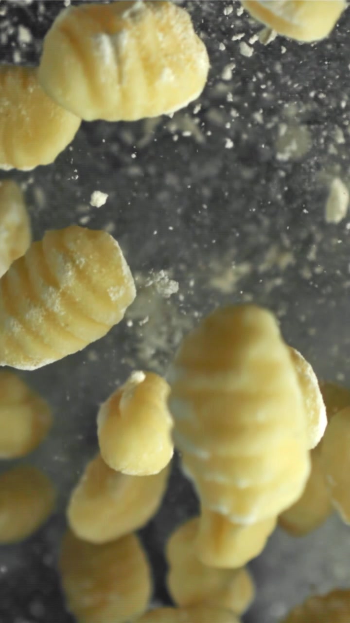 Gnocchi freschi che cadono al rallentatore con polvere di farina