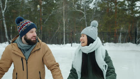 pareja patinando en el parque de invierno