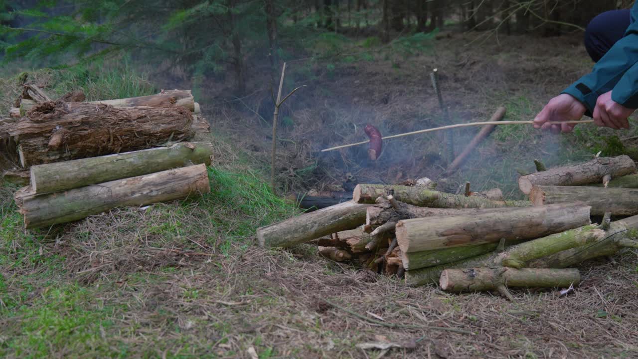 No face video of a man roasting sausages in Norfolk forest on bonfire