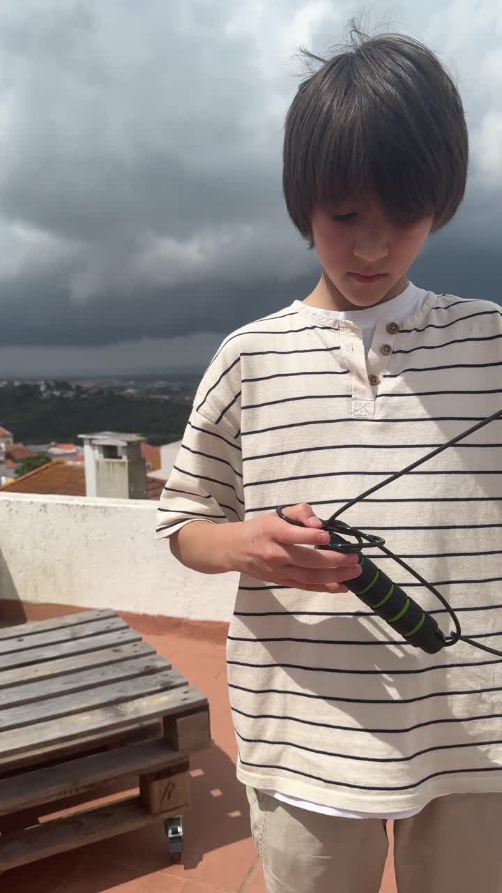 Boy skipping rope on rooftop