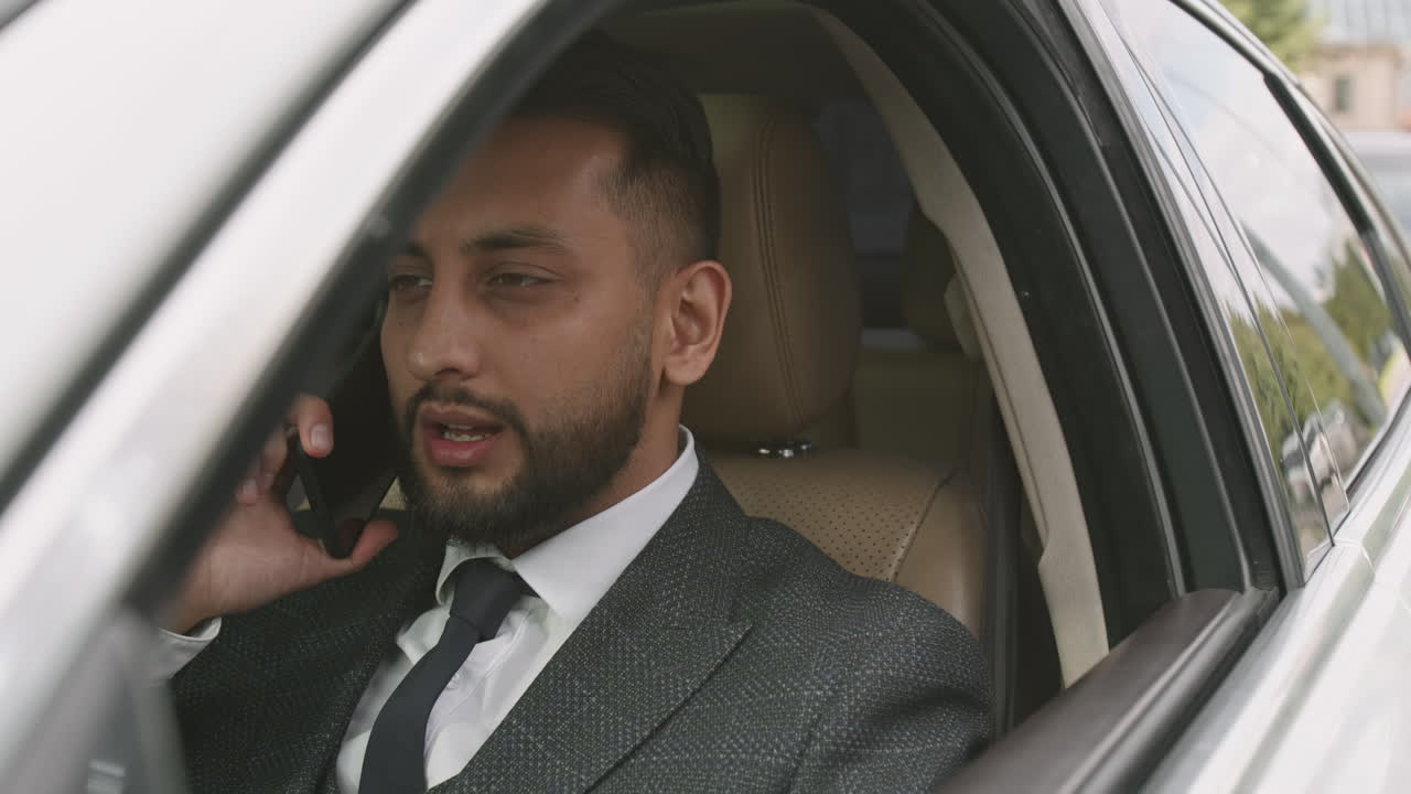 Man in Frontseat of Car Talking on Phone