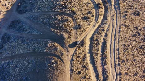 cinematic rise and rotate reveals a truck offroad with many paths, day, 4k