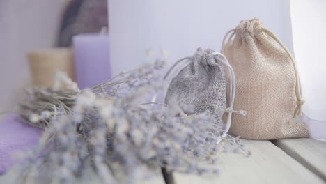 Female-hand-puts-a-bouquet-of-lavender-on-a-wooden-table