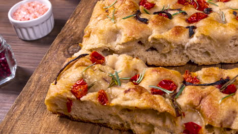 Traditionelle-Italienische-Focaccia-Mit-Peperoni,-Kirschtomaten,-Schwarzen-Oliven,-Rosmarin-Und-Zwiebeln---Hausgemachte-Fladenbrot-Focaccia