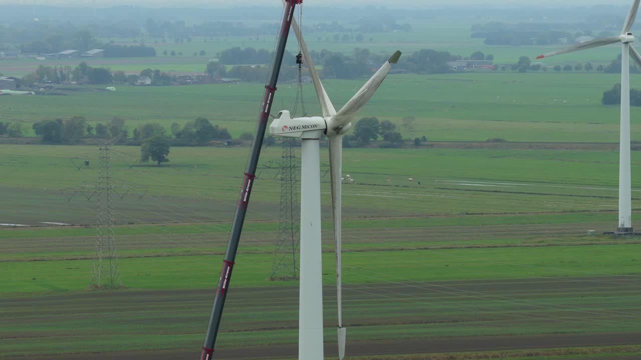 Lavori di manutenzione in corso su una turbina eolica, vista aerea con drone.