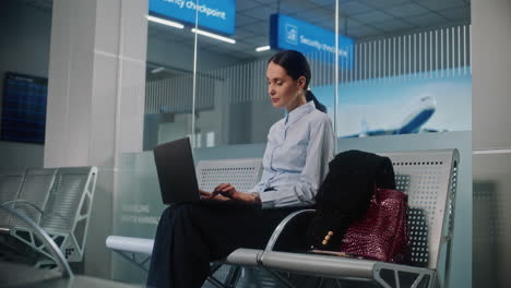 businesswoman working on laptop in airport