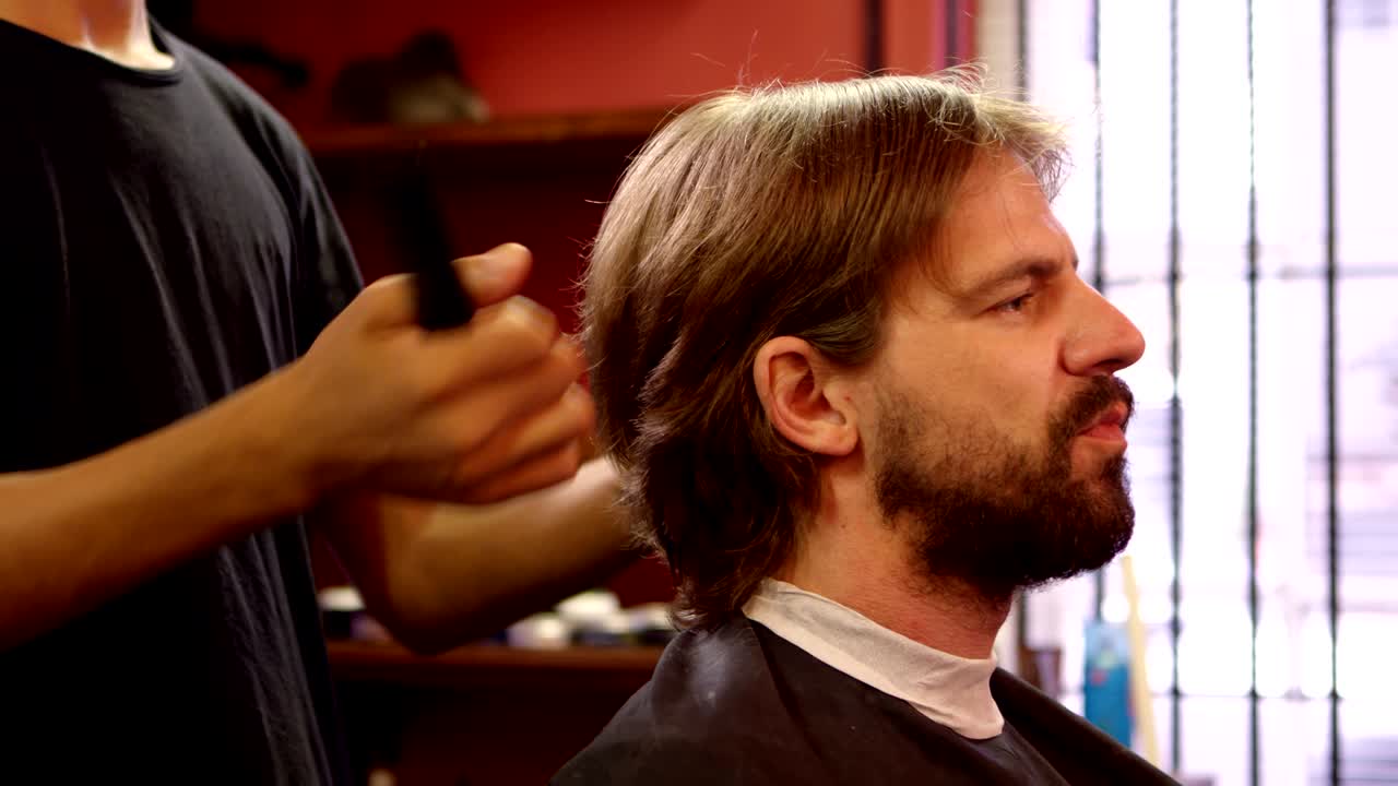 hombre cortándose el cabello por un peluquero 4k