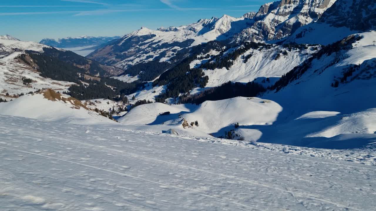 Vista panoramica dal Bühlberg attraverso la valle di Adelboden verso il lago di Thun avvolto nella nebbia in una frizzante giornata invernale, con montagne innevate che incorniciano il pacifico paesaggio alpino svizzero