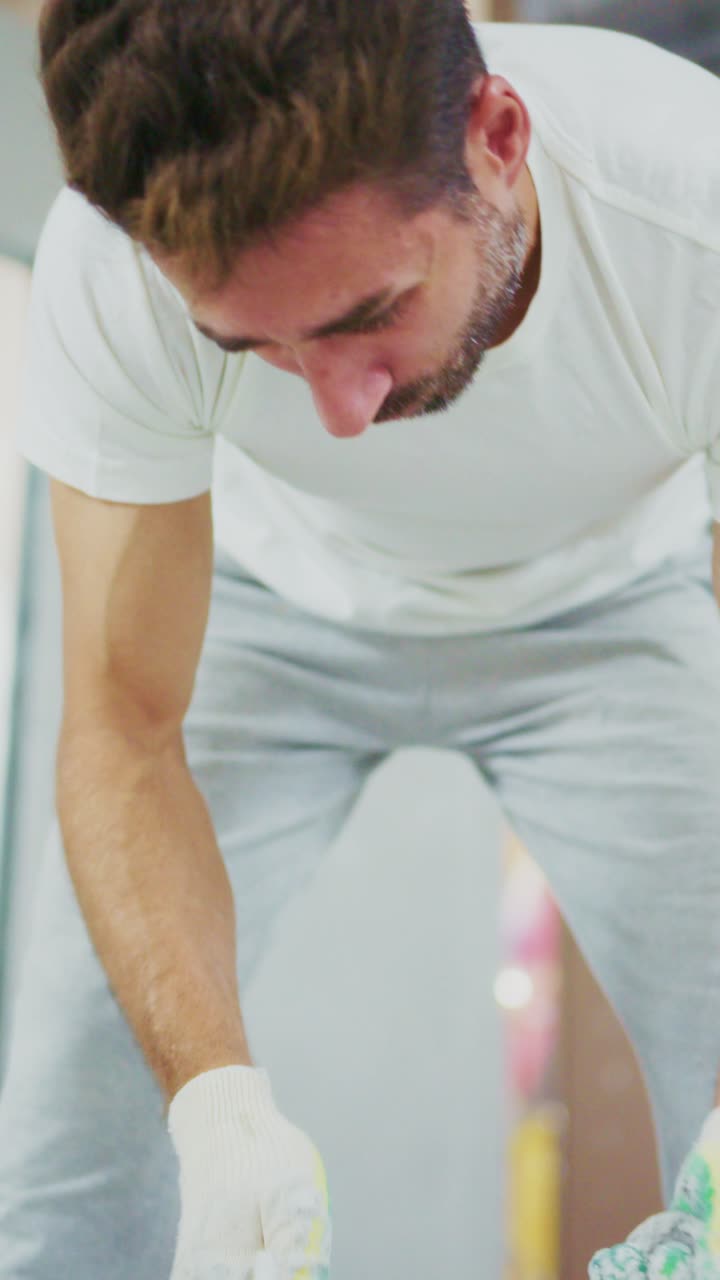 Focused Man Applying Finishing Touches with Trowel in Home Renovation Project, Showcasing Skill and Precision in Interior Craftsmanship