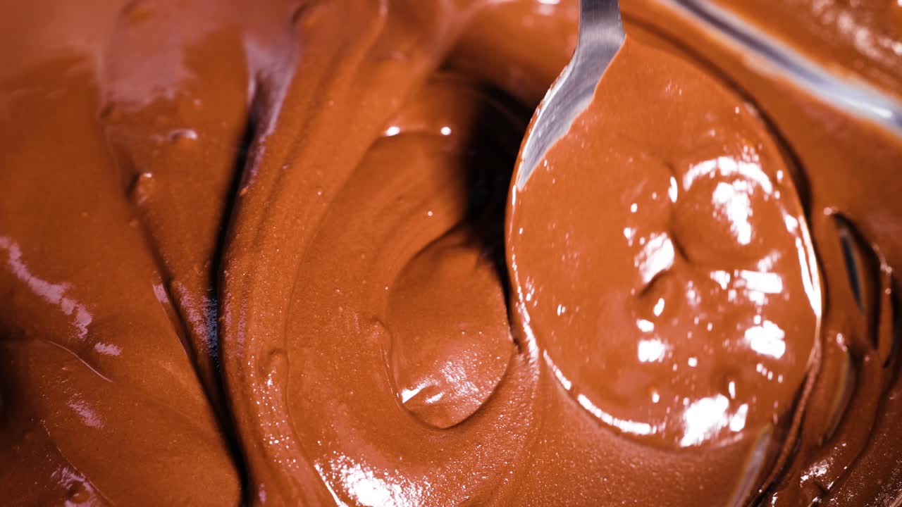 Un cucchiaio mescola cioccolato cremoso in una ciotola