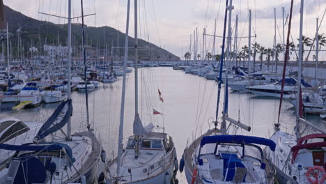 Zeitraffer-Von-Yachten,-Die-Im-Hafen-Angedockt-Sind-Und-Sich-In-Den-Wellen-Bewegen,-Während-Wolken-Sich-Schnell-Bewegen-Und-Sonnenlicht-über-Die-Szene-Scheint