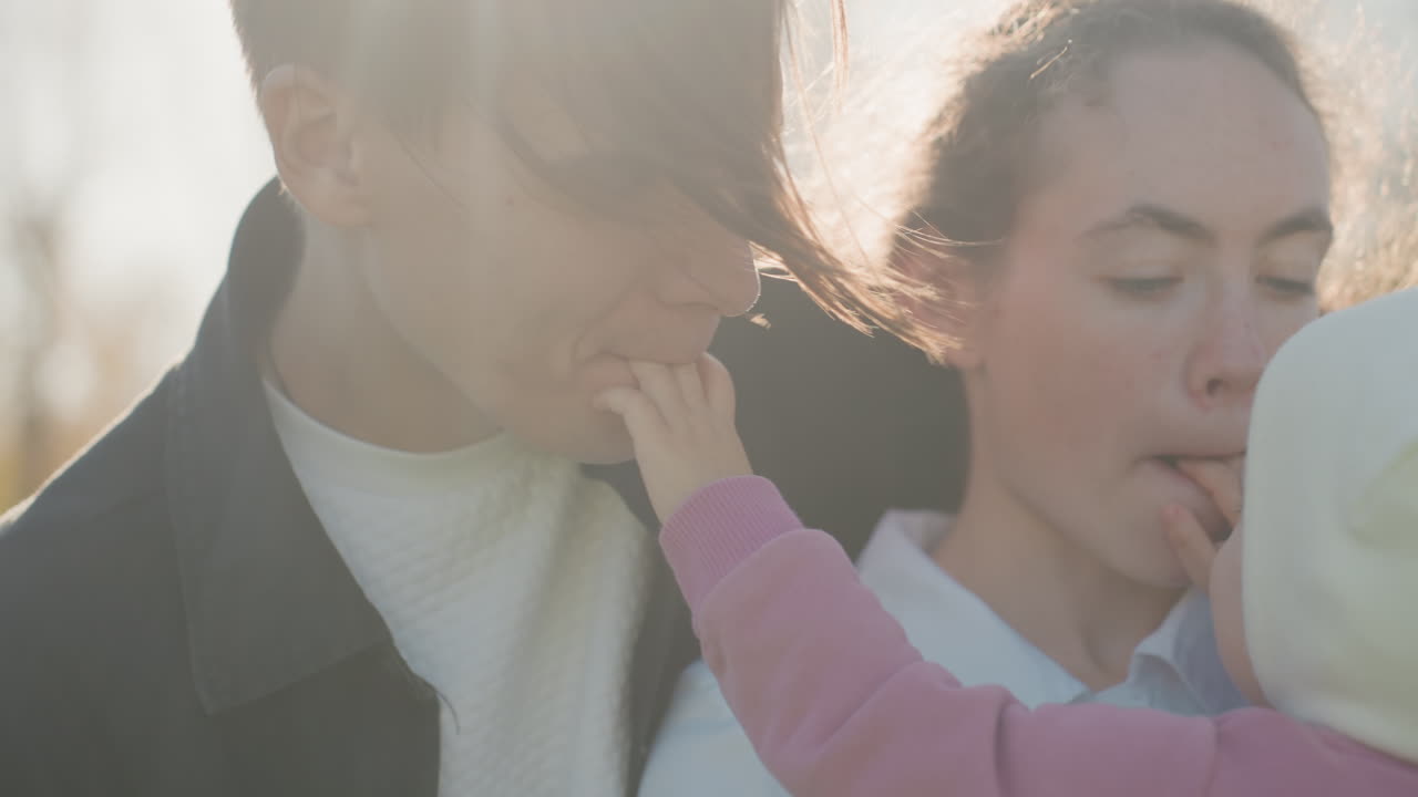幼児が遊び心のある親子のひとときを楽しむ。小さな子供が家族と陽気な触れ合いと愛情深い笑い声を分かち合う。幼児が遊び心のある仕草と温かい笑顔で愛する人々と楽しく触れ合う