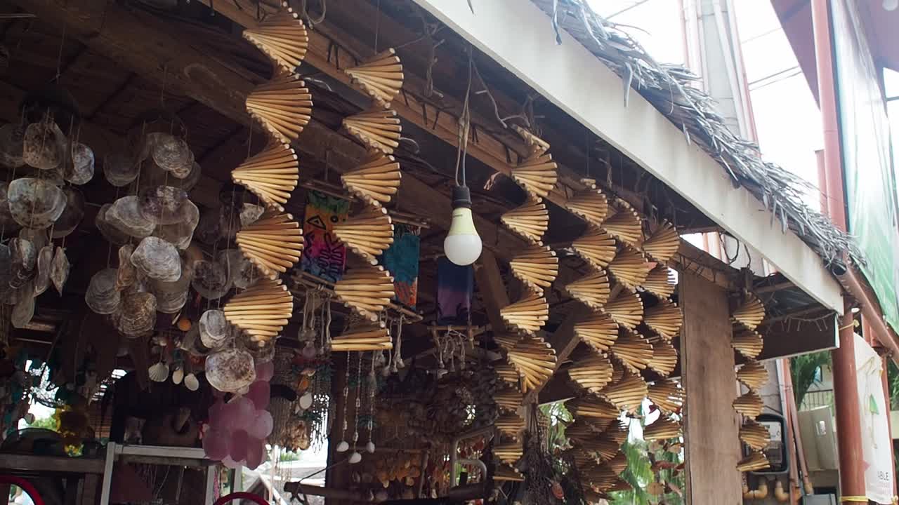 Decorative wooden helix kinetic wind spinners hanging at the front of a tropical souvenir shop