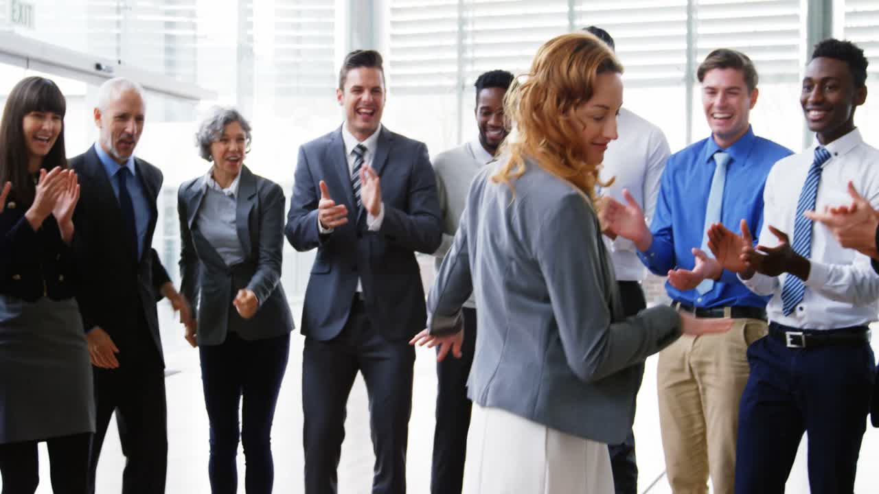 Businesswoman dancing while her colleagues applauding