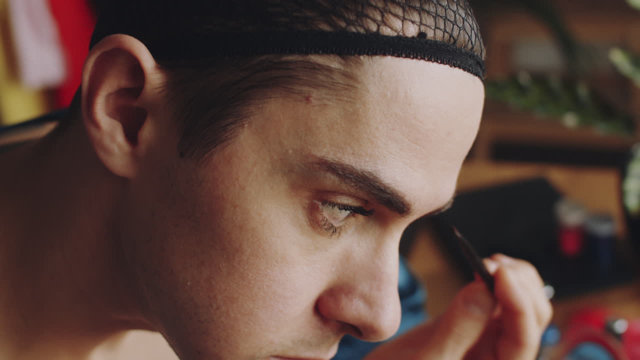 трансгендерный мужчина наносит тени на брови