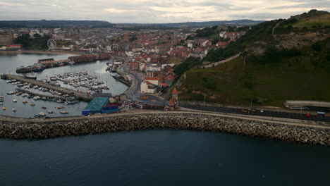 long establishing drone shot around scarborough harbour at dawn