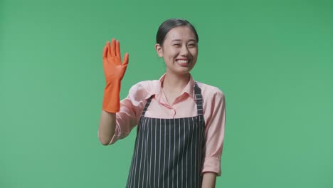 mujer con delantal y guantes agitando