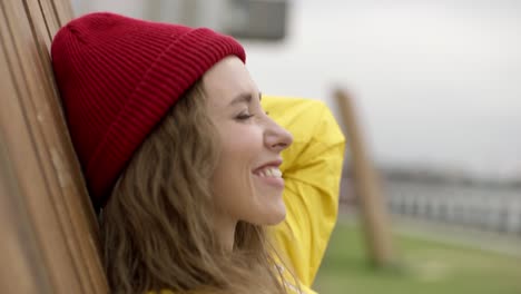 eine junge dame saß auf einem holzstuhl und machte selfies mit ihrem handy