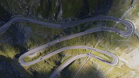 static aerial shot over section of winding mountain road with cars