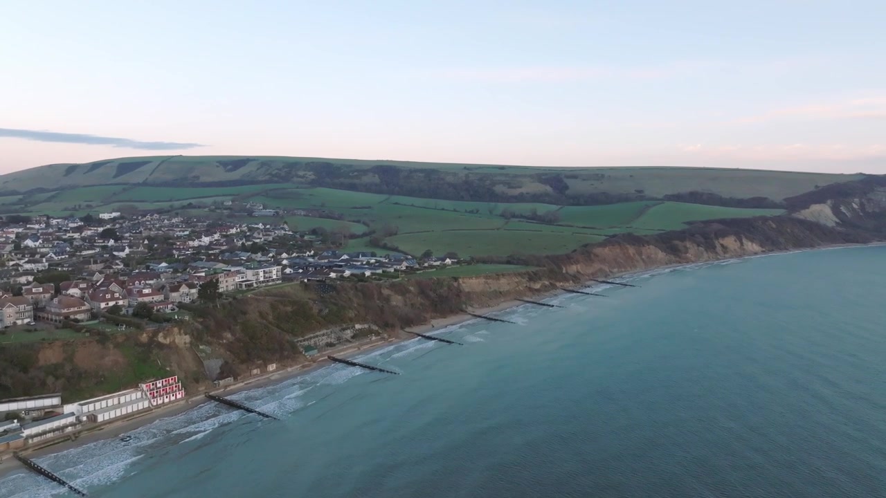 Nascer do sol em Swanage, Reino Unido, vista aérea ampla voando de volta em direção à costa