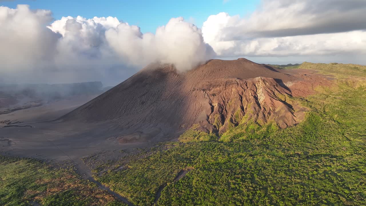 Smoke from active volcano in Tanna Island, Vanuatu. Drone pull back, sunset, golden hour landscape.