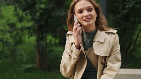 estudiante caucásica hablando por teléfono al aire libre.