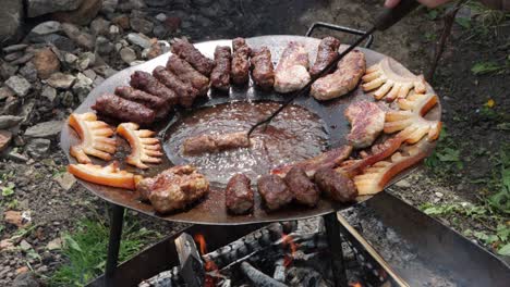 La-Persona-Mueve-El-Mititei-De-La-Grasa-Caliente-En-El-Centro-Del-Disco-Para-Asar-Al-Borde-Para-Terminar-De-Cocinar