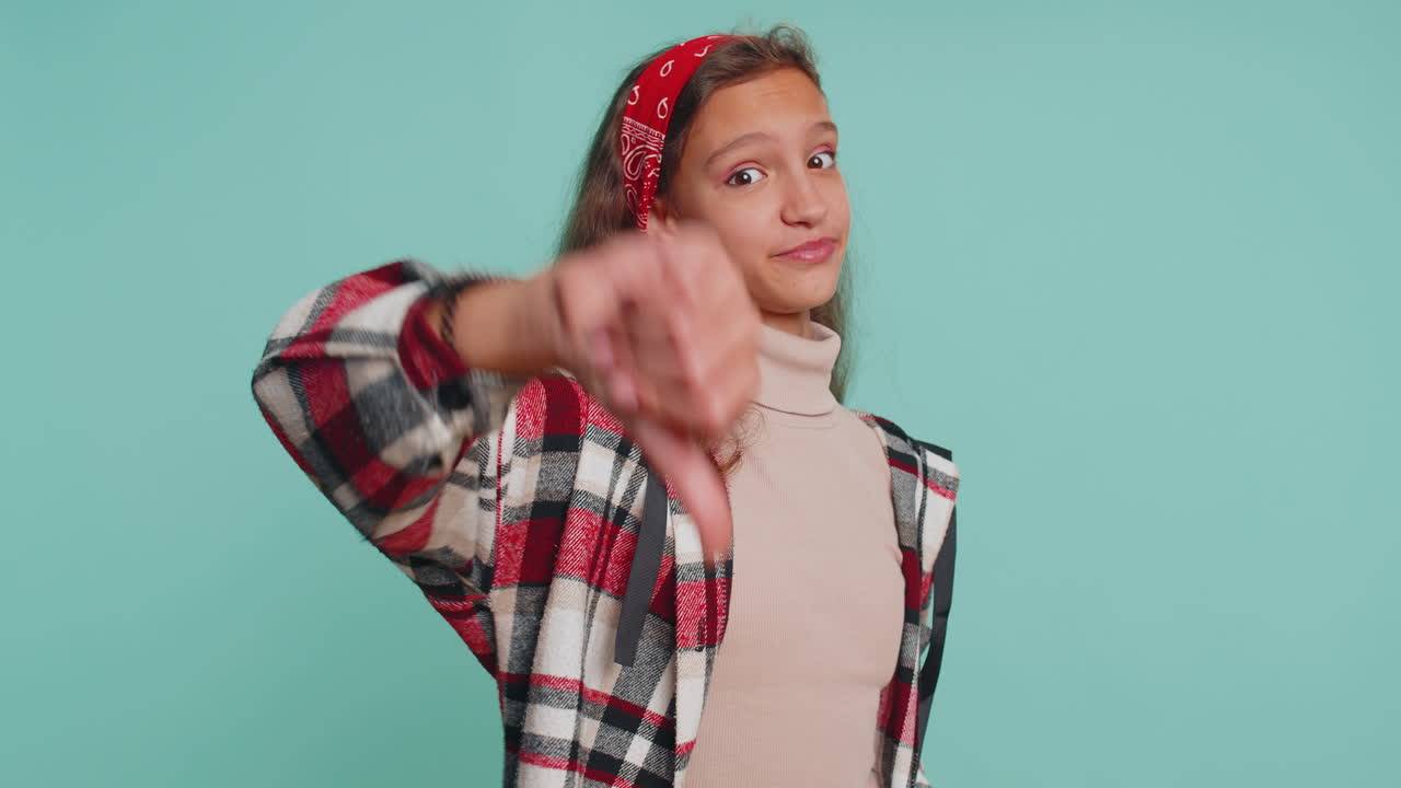 niña adolescente molesta mostrando pulgares hacia abajo, no le gusta el mal trabajo, desaprobación, retroalimentación insatisfecha