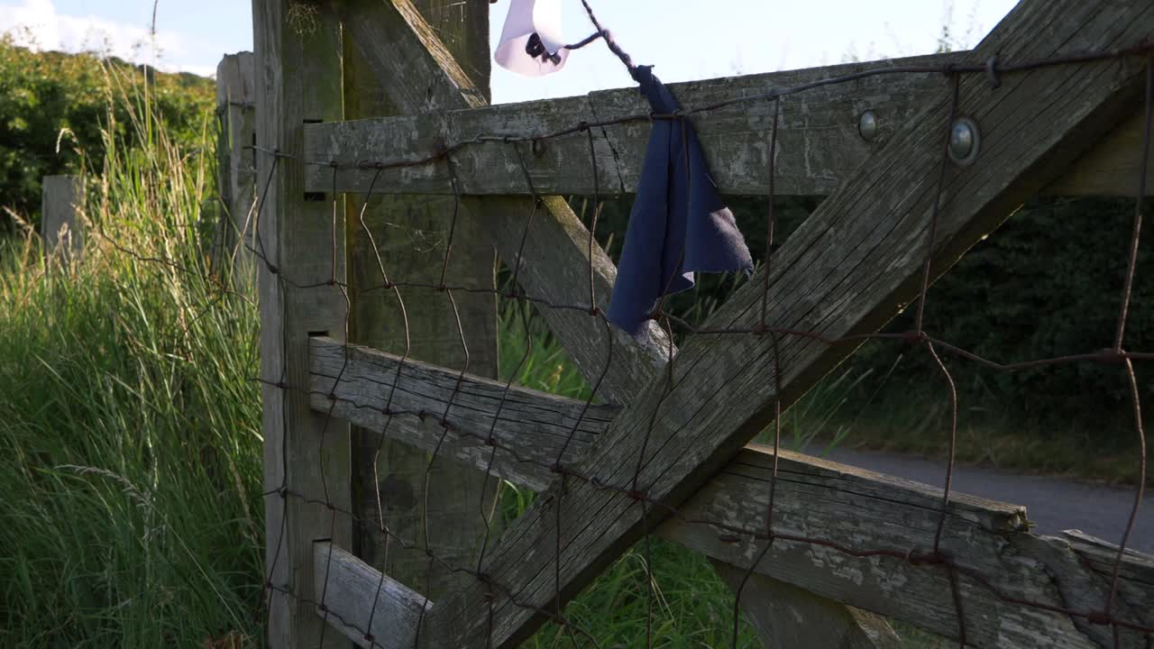 Rickety wooden gate in farmers field medium panning shot