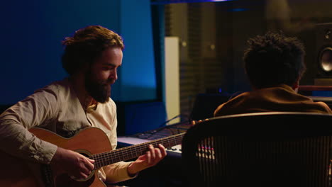 performer songwriter singing new tracks on his electro acoustic guitar