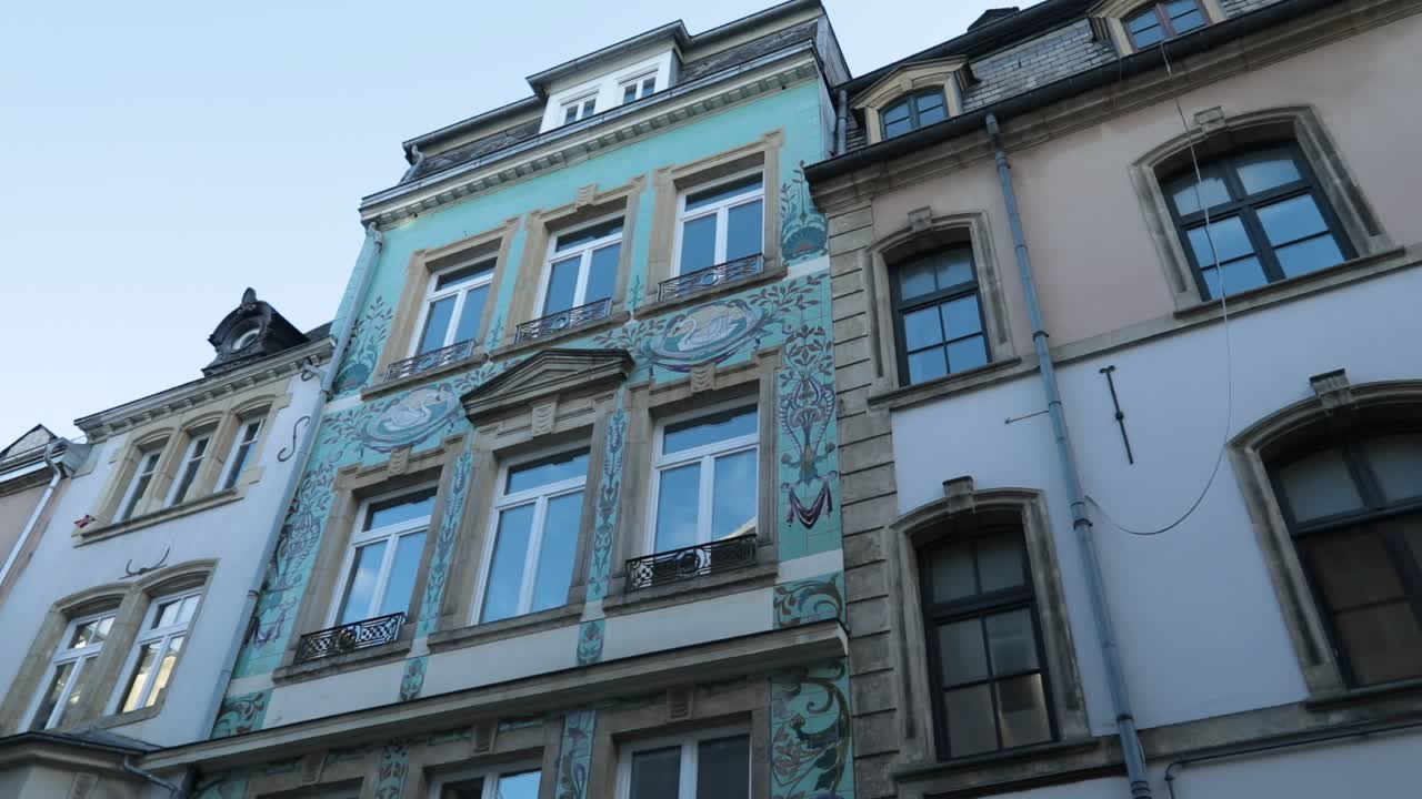 Esterno colorato di un edificio storico contro un cielo azzurro limpido, atmosfera calma.