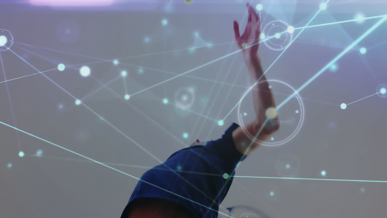 Tennis player serving in gym, overlaying glowing network graphics for sports technology