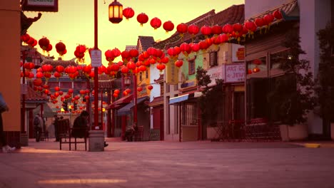 tourists walking under red lanterns during a china sunset